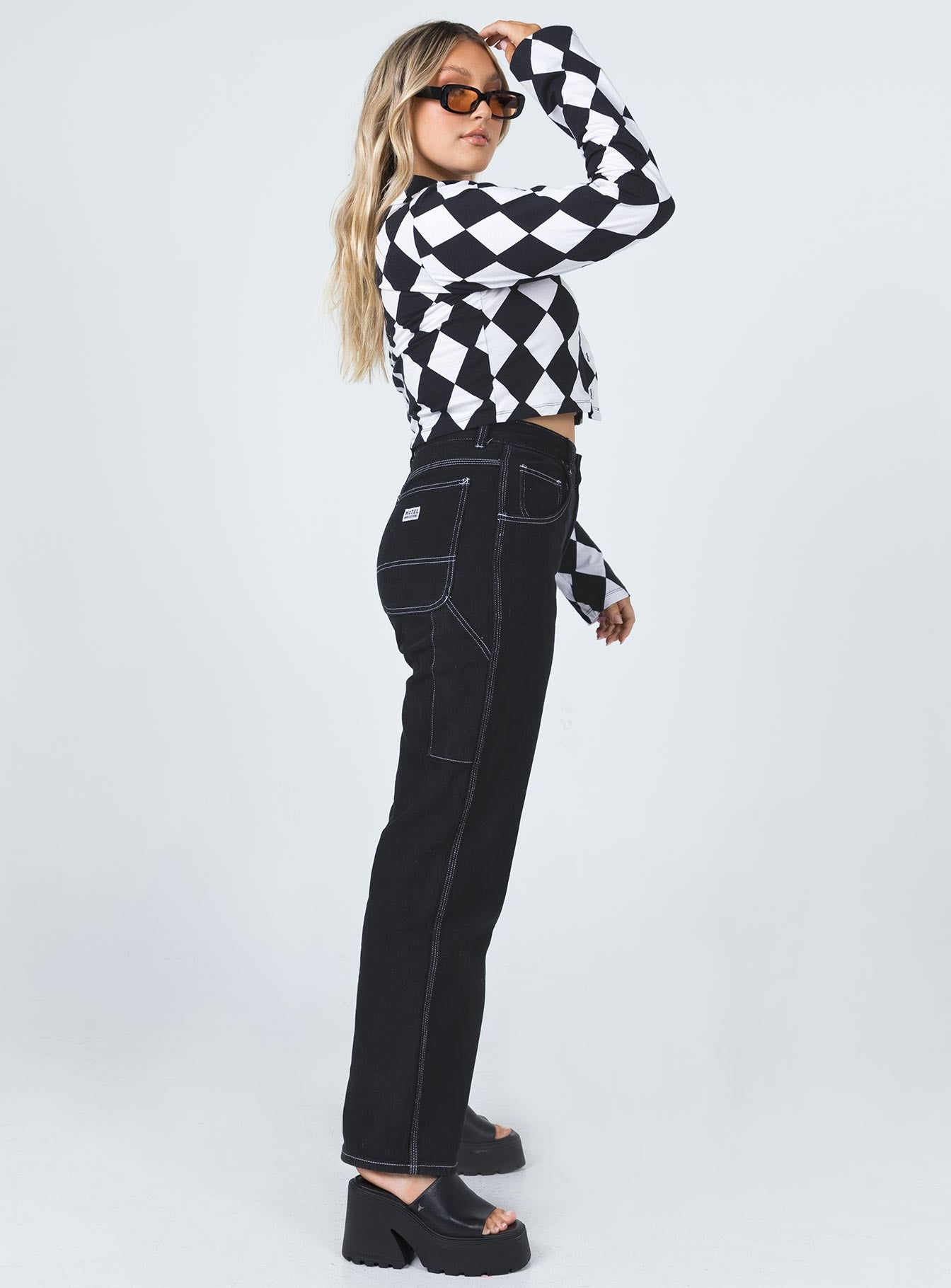 side view of model wearing Princess Polly Motel Carpenter Jeans Black Mid Rise 