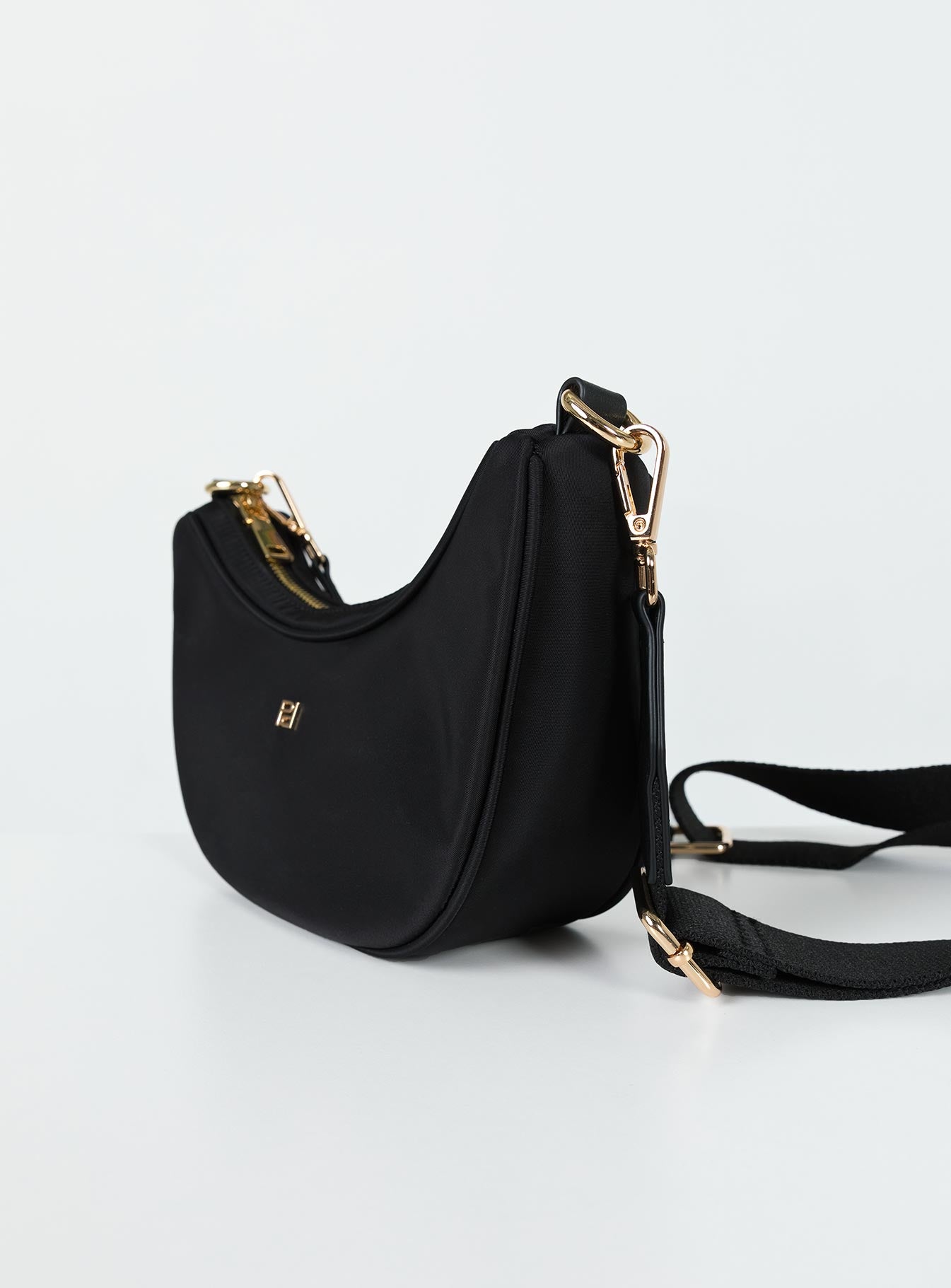 Crossbody bag Zip fastening Gold-toned hardware Two internal pockets Flat base