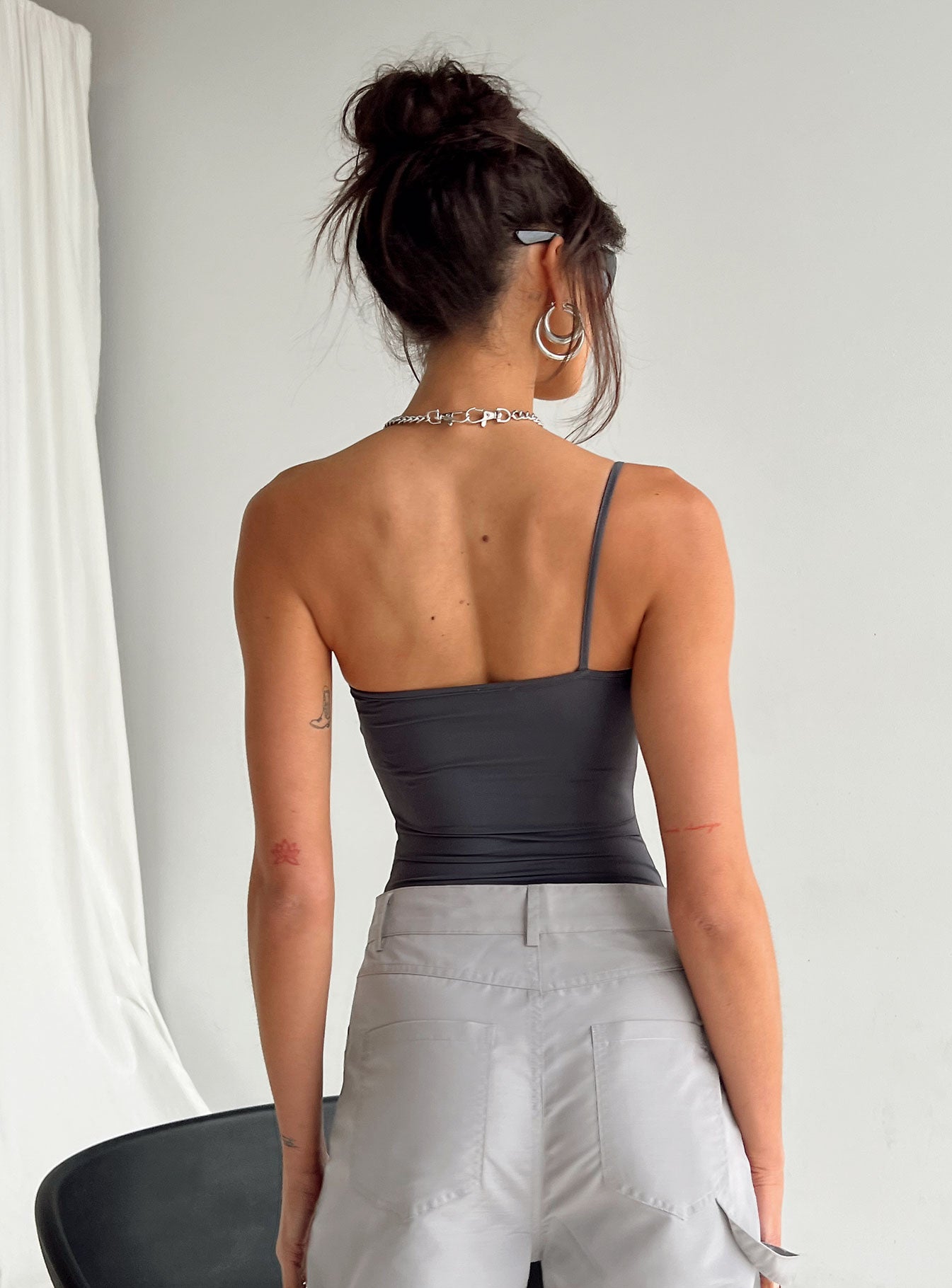 back view of model wearing Princess Polly Hutter Bodysuit Grey Sleeveless Asymmetric Neckline 