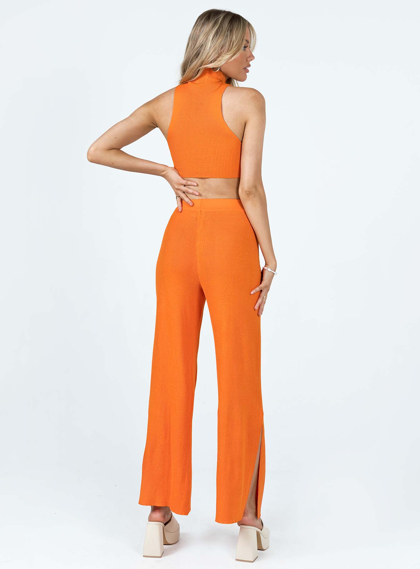 Matching set Ribbed material Tank top Mock neck Low cut sides High waisted pants Elasticated waistband Wide leg Slits at cuff