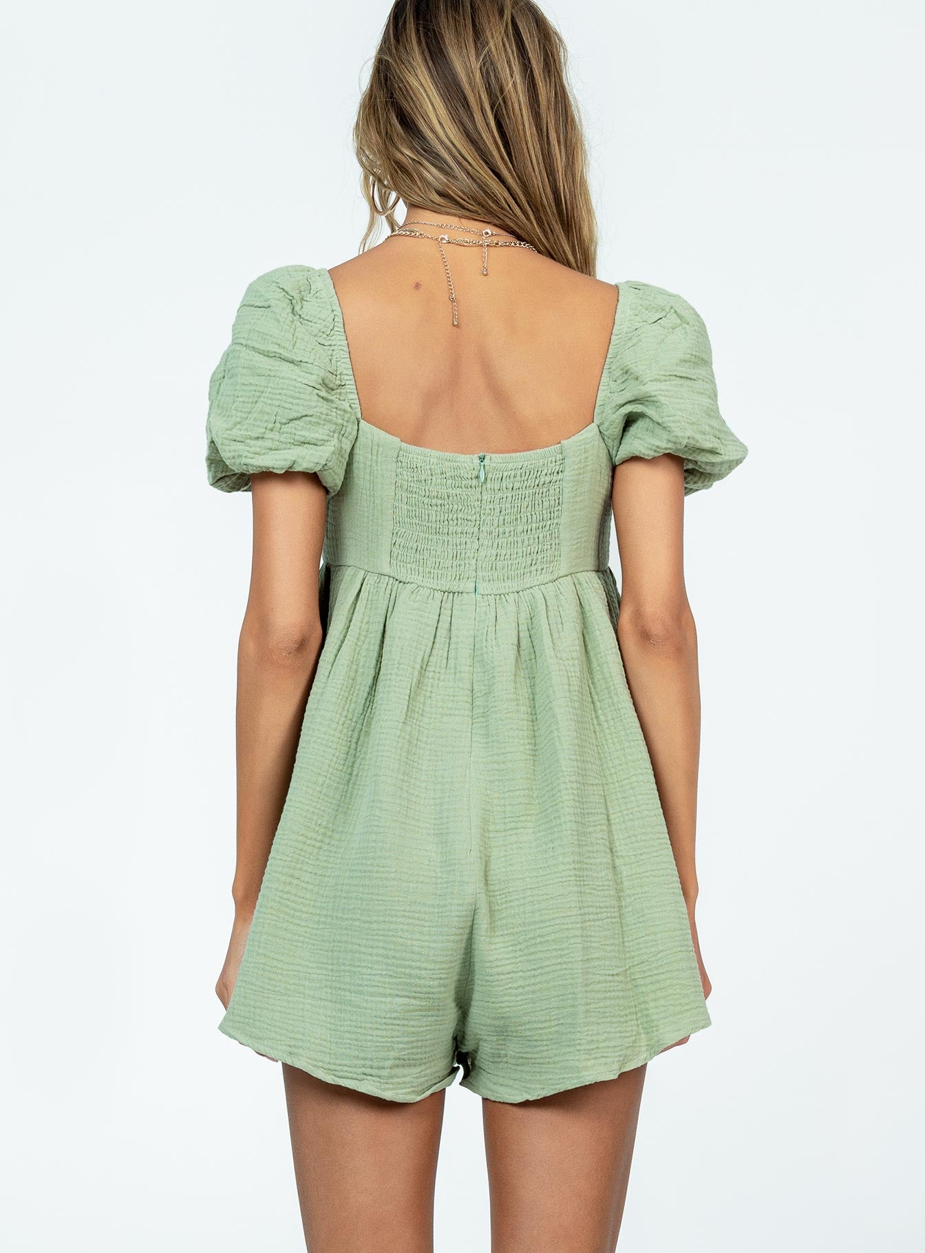 Green romper Muslin material Square neckline  Elasticated puff sleeves Shirred back panel Invisible zip fastening at back  Relaxed leg 