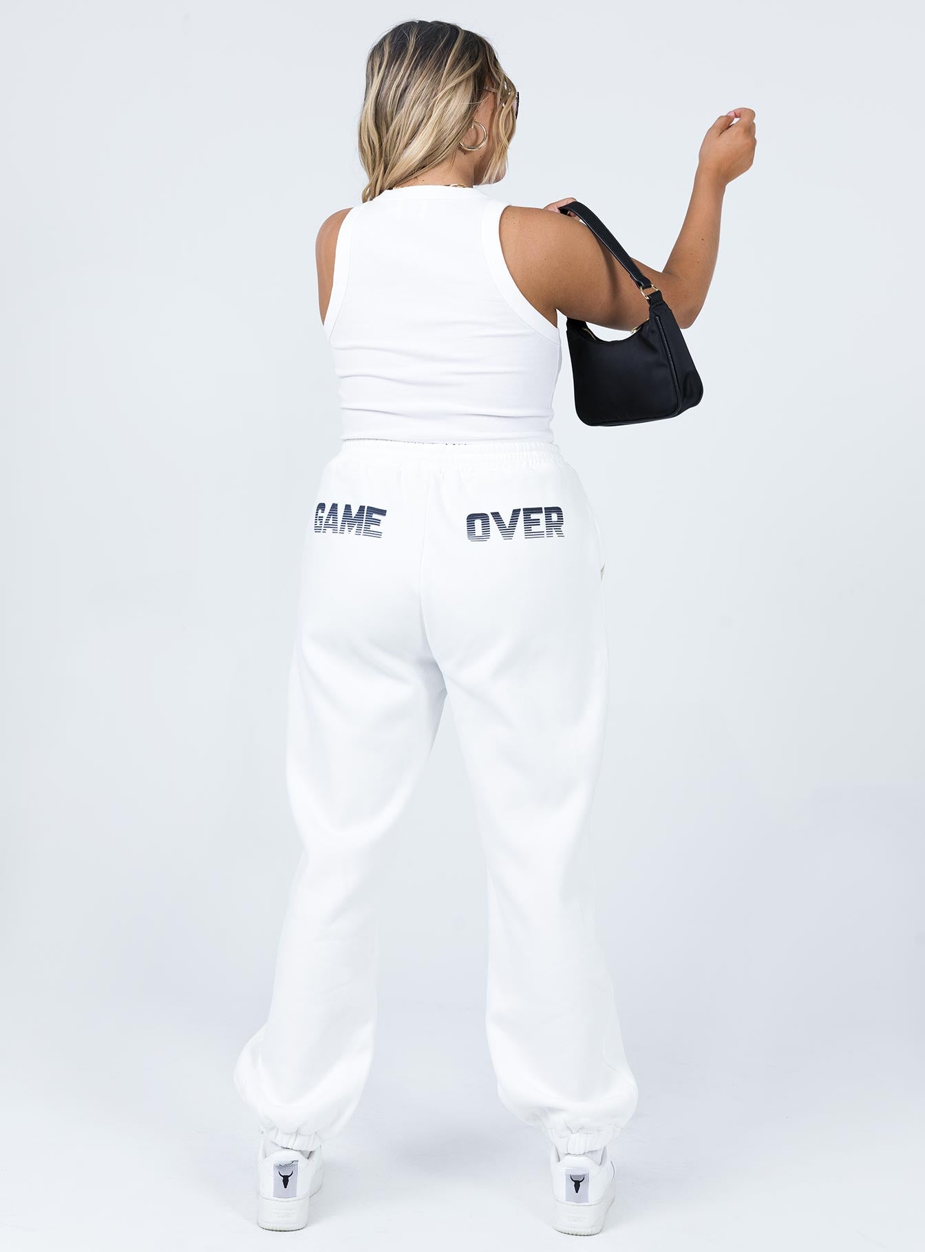 back view of model wearing Princess Polly Jasmine Graphic Track Pants White 