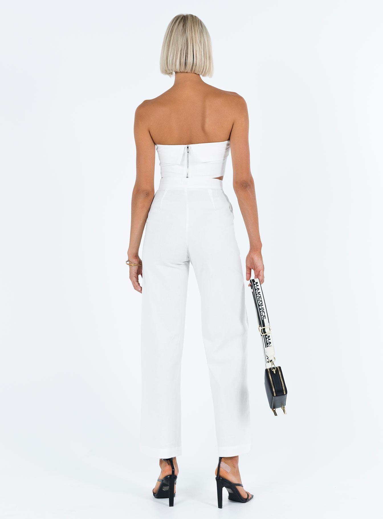 White matching set Linen look material Strapless crop top Folded neckline Inner silicone strip at bust Zip fastening at back High waisted pants Front button and zip fastening  Twin hip pockets