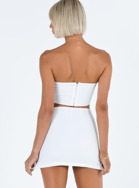 White two piece set Strapless crop top Pearl embellishments at bust Boning through bust Invisible zip fastening at back  Mini skirt Side split Invisible zip fastening at side