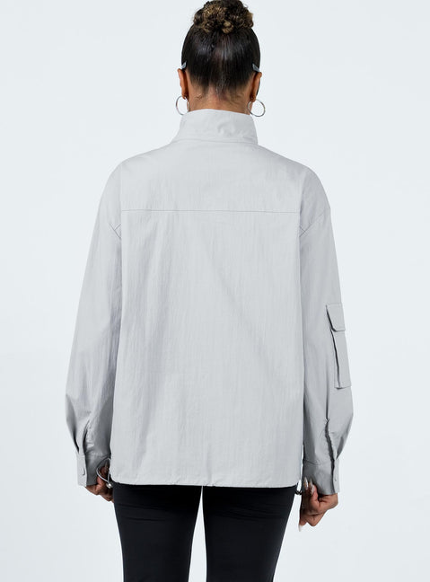 Jacket Windbreaker material High neck Zip front fastening Cargo style pocket on right sleeve Twin front pockets Press studs at cuff Drawstring hem