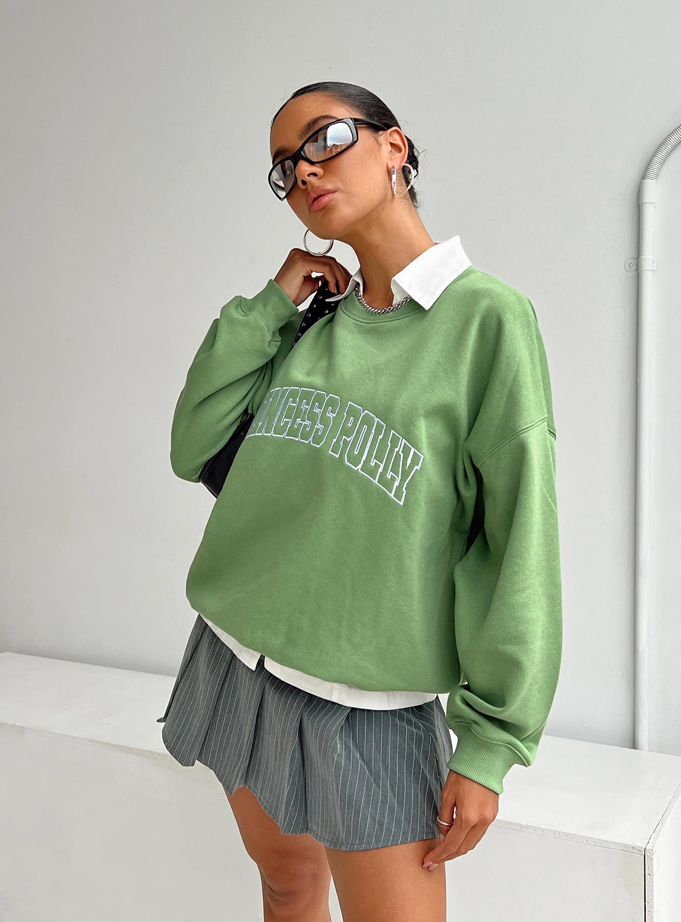 side view of model wearing Princess Polly Princess Polly Crew Neck Sweatshirt Collegiate Text Green 