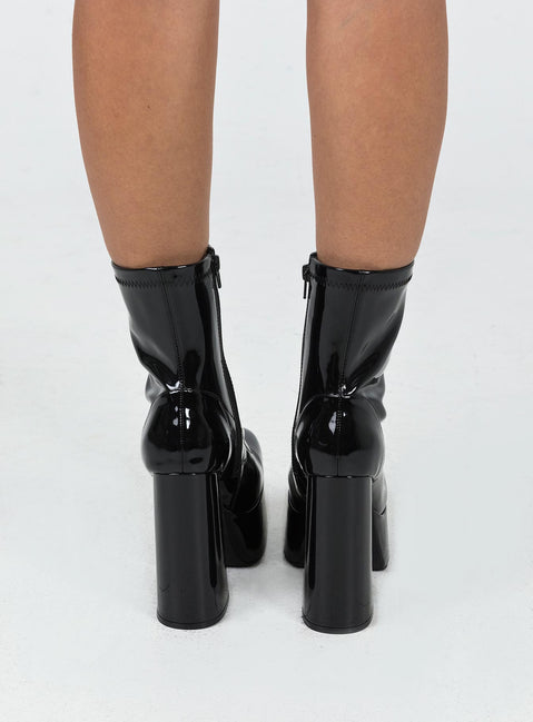 Platform boots Faux patent leather material Zip fastening at side Block heel Rounded toe Padded insole 