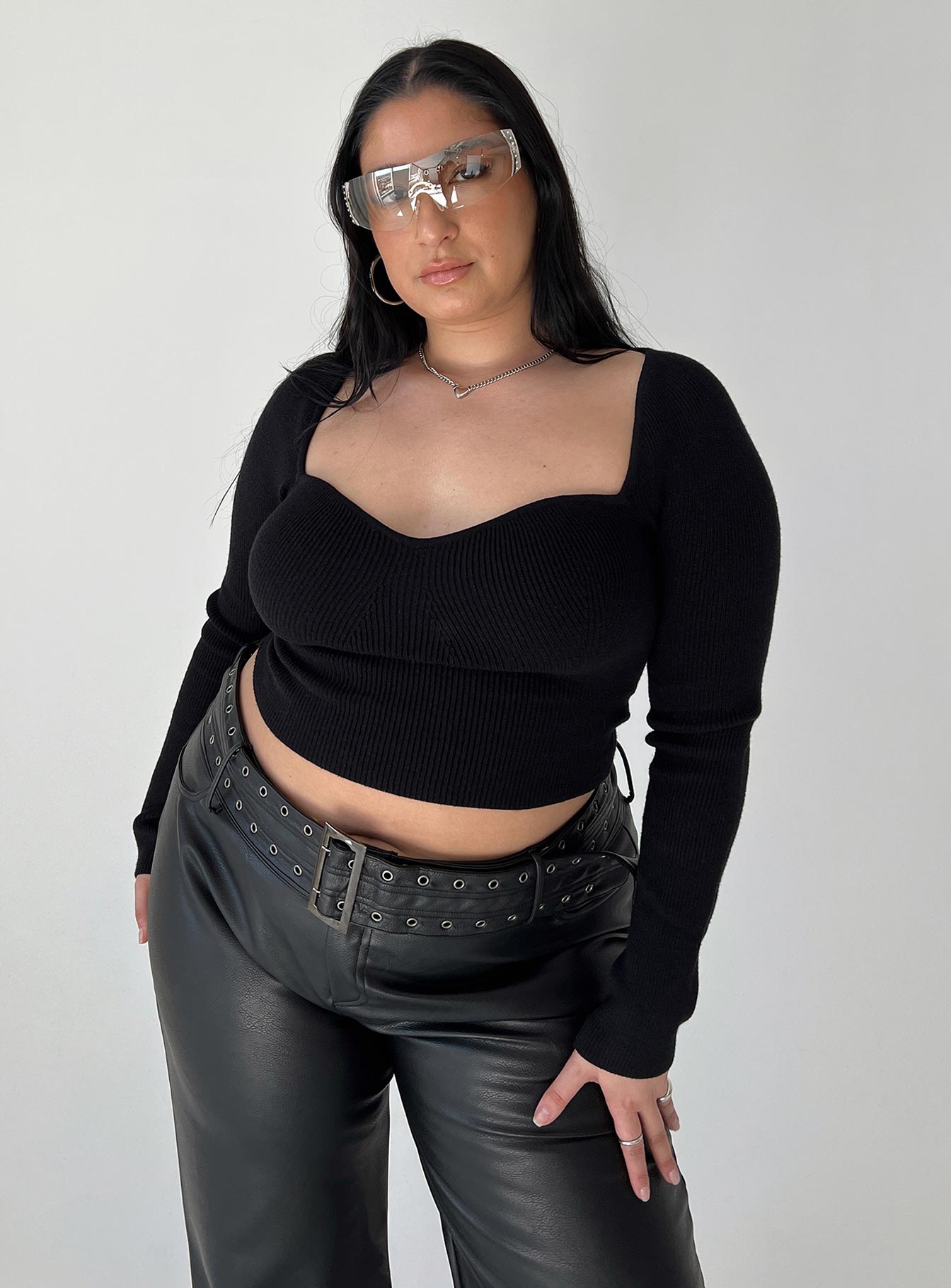 Front view of model wearing  front Princess Polly High Waisted Pants  Torridon Eyelet Belt Faux Leather Pants Black Curve