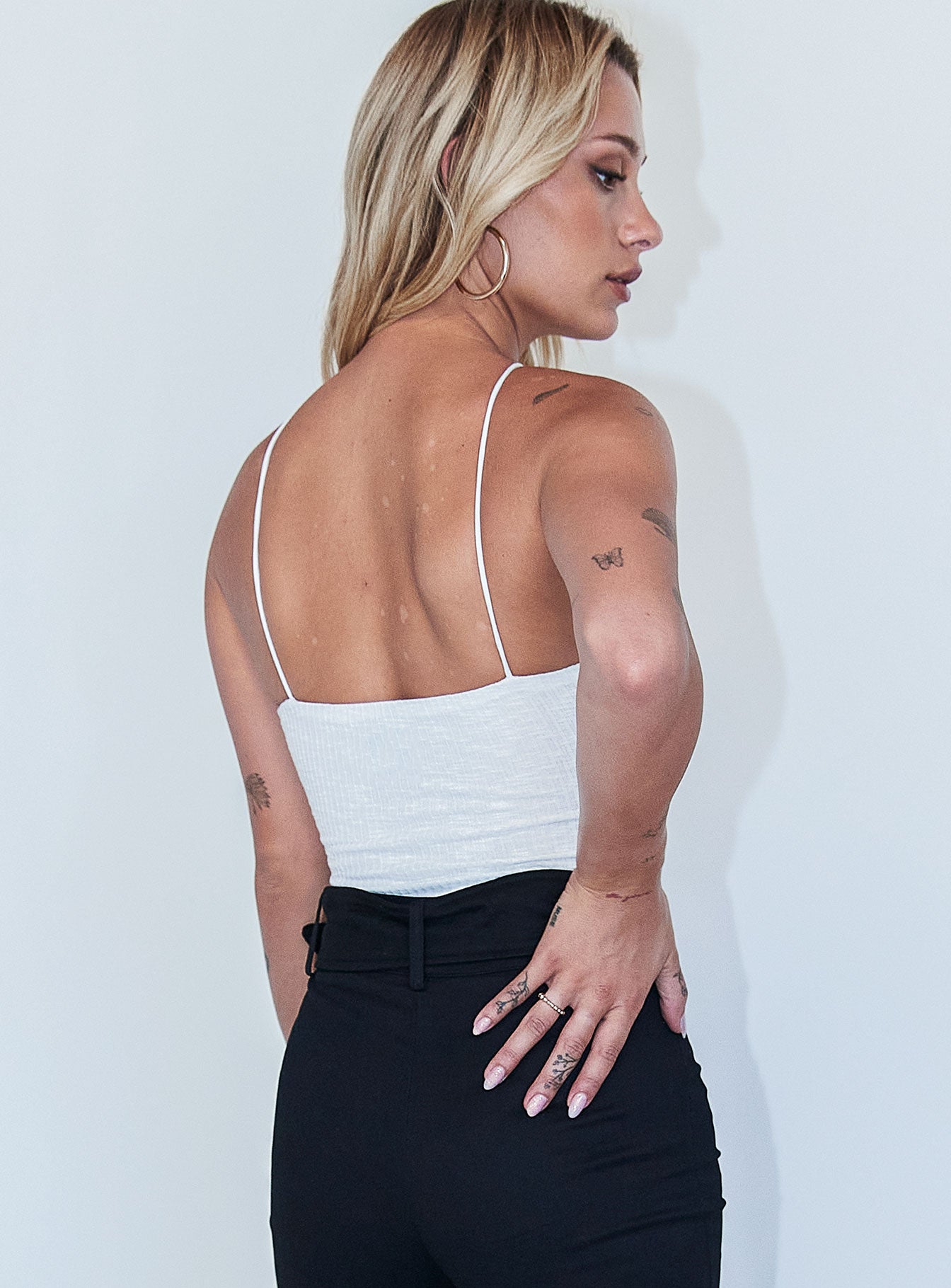 back view of model wearing Princess Polly Morgan Bodysuit White Sleeveless Asymmetric Neckline 