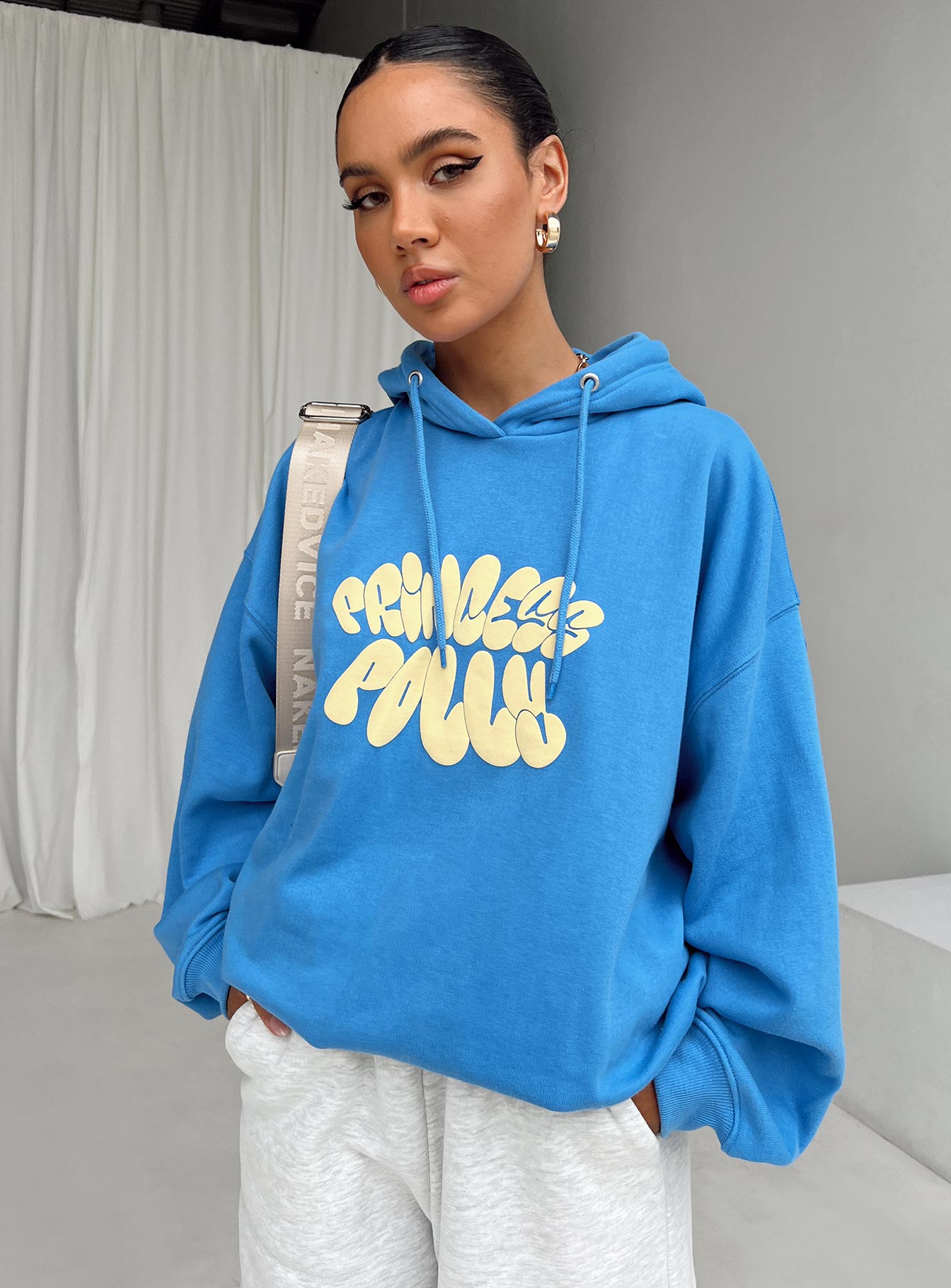 front view of model wearing Princess Polly Princess Polly Hooded Sweatshirt Bubble Text Blue / Yellow Long 